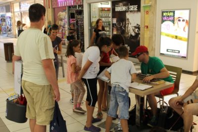 In the picture our visually impaired colleague is sitting at a table surrounded by people and they are talking to each other.