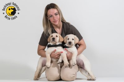 Királyné Barkóczi Emese két kölyökkutyával az ölében