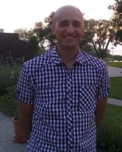 A képen Barnabás mosolyogva, egyedül áll egy parkban