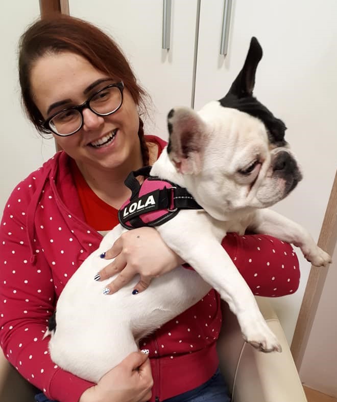 Adrienn ül egy széken és az ölében van egy fekete fehér francia bulldog