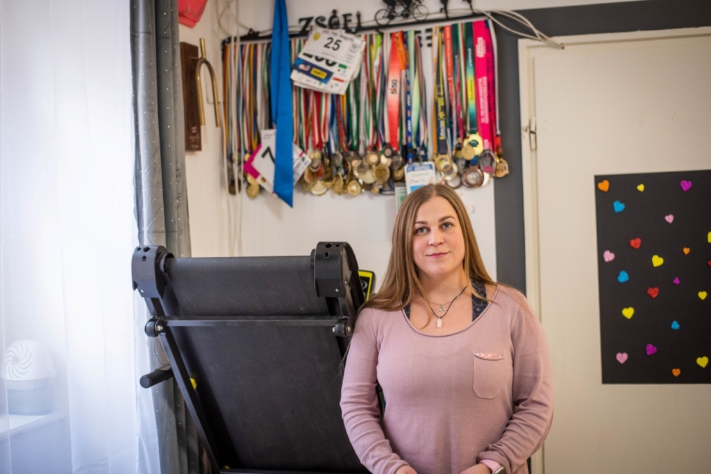 Lengyel Zsófi áll a képen háttérben a parasportban szerzett érmei.