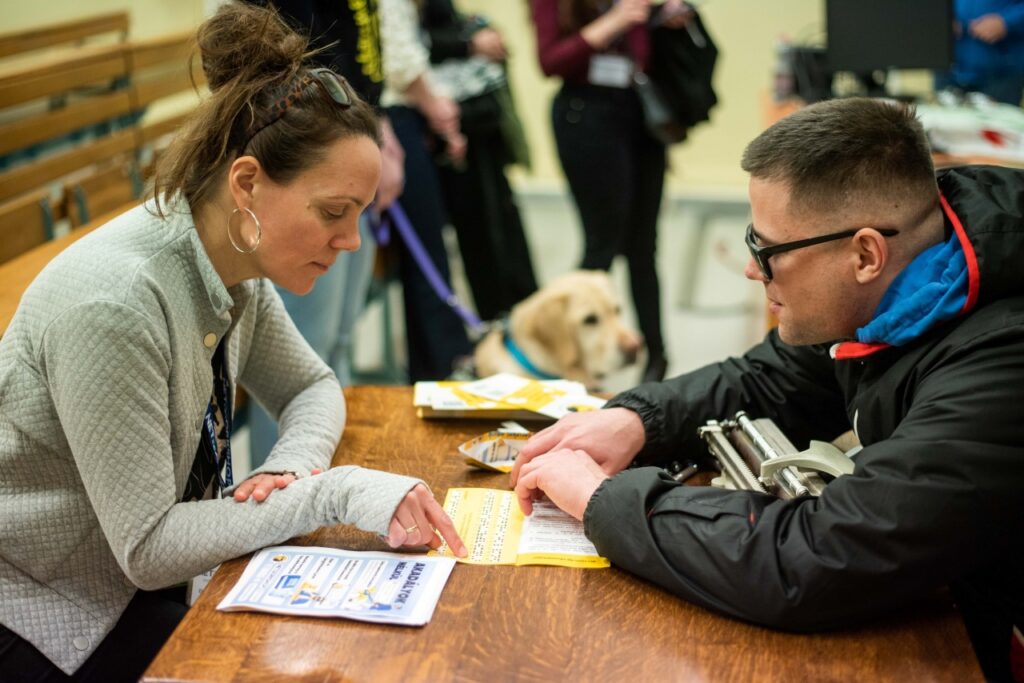 Vida Zoltán a Braille-írást szemlélteti a rendezvény egyik érdeklődőjének.